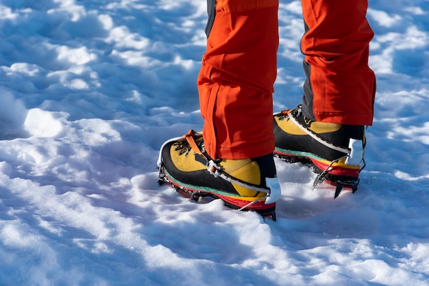 Escalador de hielo con crampones en botas de montaña - Fotografía de stock