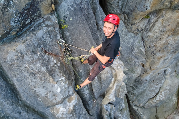 Escalador masculino fuerte escalada empinada pared de montaña rocosa. Deportista superando ruta difícil. Participar en el concepto de pasatiempo de deportes extremos.