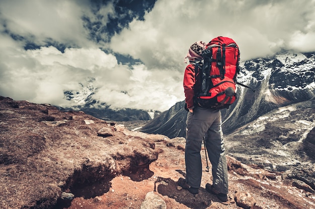 Escalador de pie en una montaña y disfrutando de la vista