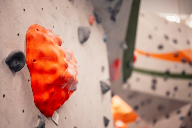 Escalador usando equipo de escalada Practicando escalada en roca en una pared de roca en interiores Deportes extremos y concepto de boulder