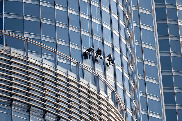 Los escaladores industriales lavan las ventanas del rascacielos en altitud