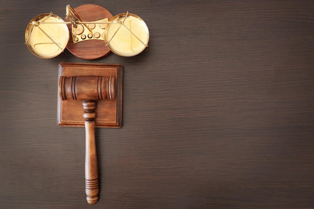 Foto escalas de justiça e martelo do juiz em cima da mesa de madeira