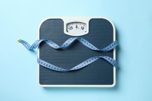 Foto escalas e fita métrica no chão azul. conceito de perda de peso