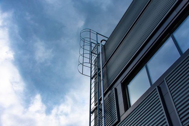 Escalera al cielo. Escalera de metal en el edificio con el telón de fondo del cielo y las nubes.