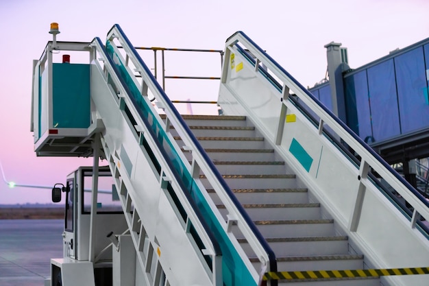 Foto escalera de avión para el desembarque y el embarque de pasajeros a bordo del avión.
