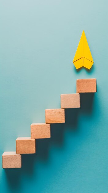 Foto escalera de bloque de madera con avión de papel amarillo cielo azul claro aspiración de elevación multitud vertical