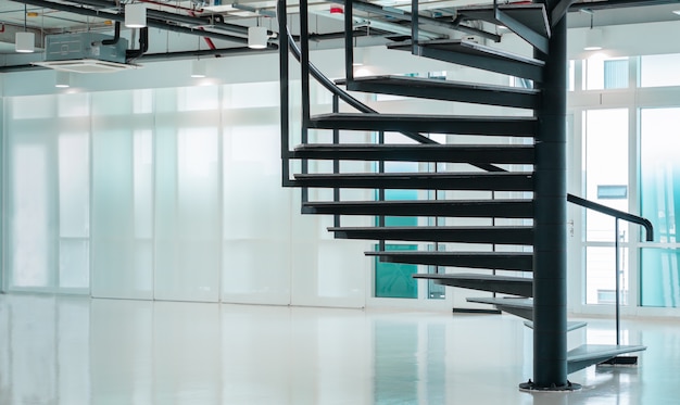 Escalera de caracol moderna negra en la oficina de negocios con ventanas, diseño de escalera de piso interior contemporáneo