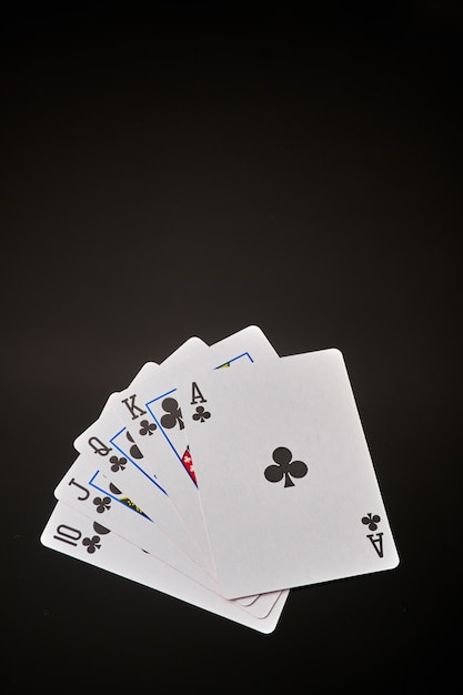 Escalera de color jugando a las cartas sobre fondo oscuro