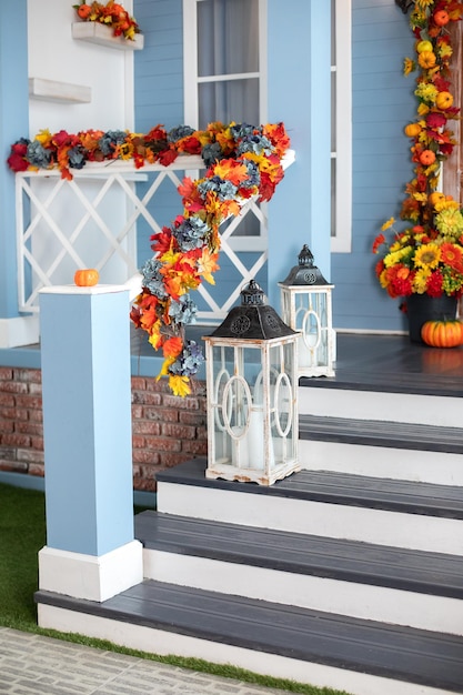 Escalera de entrada a la casa decorada para el otoño, con farolillos de madera