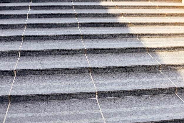 Escalera grande con textura gris piedra, escalera ancha de granito, vista frontal. Escaleras anchas de piedra, escaleras abstractas, escaleras en la ciudad, escaleras de granito, escaleras de piedra que a menudo se ven en lugares emblemáticos y monumentos.