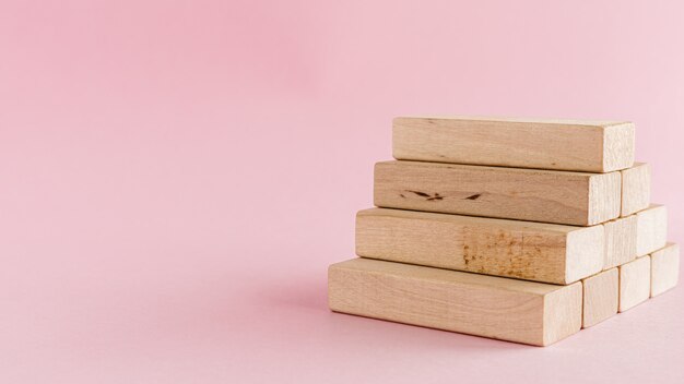 Escalera de juguete de madera en pared rosa