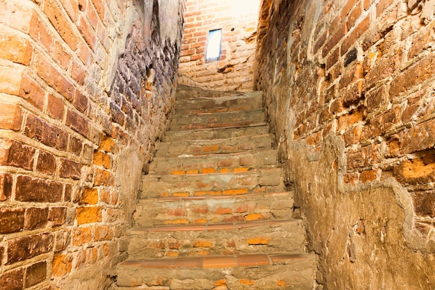 Escalera de ladrillo con escaleras en el antiguo pasillo del castillo