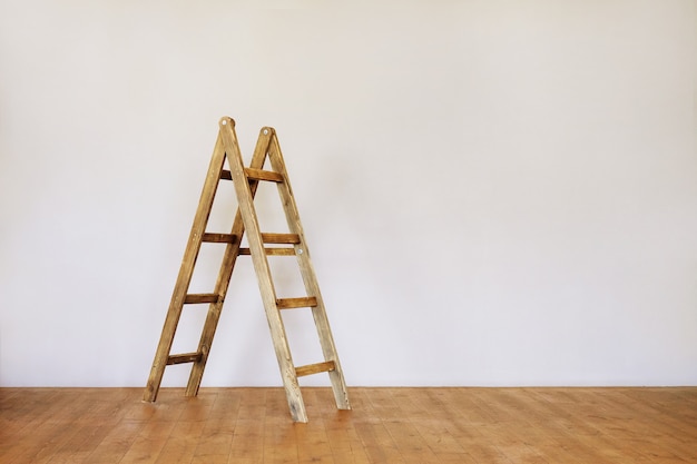 Foto escalera de madera en una habitación estilo loft vacía con espacio para texto.