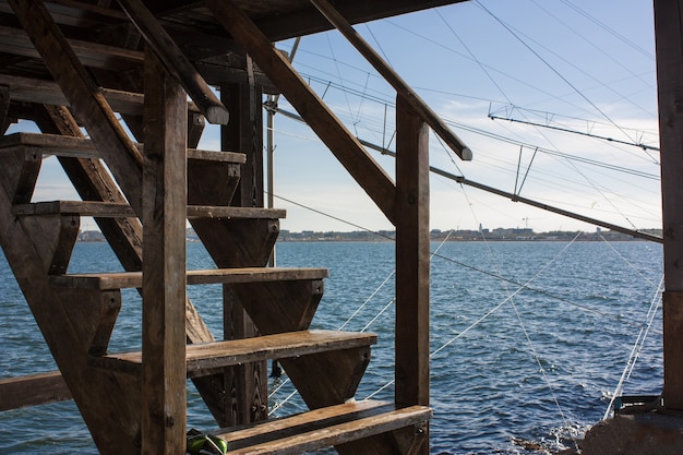 Escalera de madera un restaurante rústico en una presa en el mar en Italia.