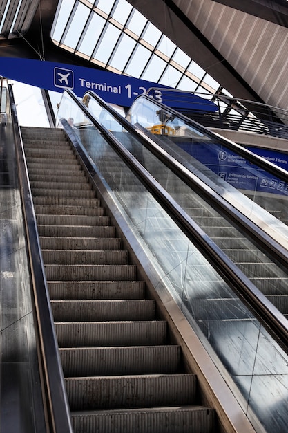 Escalera mecánica en el aeropuerto de Francia con panel terminal