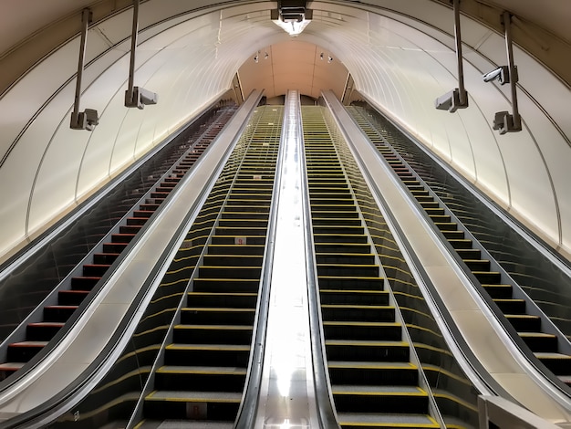 Una escalera mecánica vacía en el metro. Transporte de personas arriba y abajo de escaleras. Cuatro escaleras mecánicas sin gente. Mall, elevar