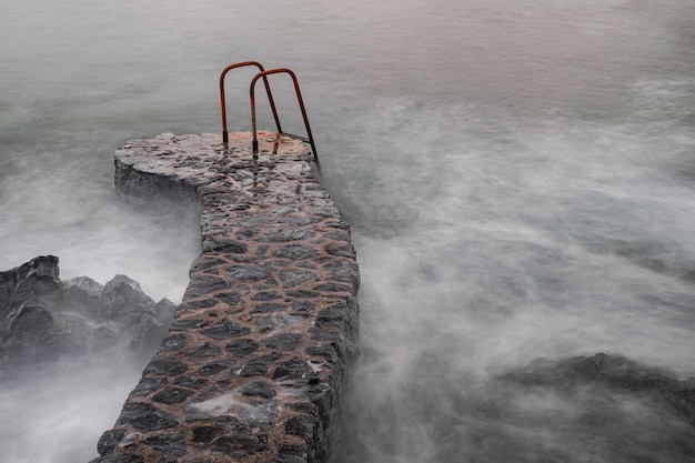 Escalera de metal oxidado en el océano Atlántico