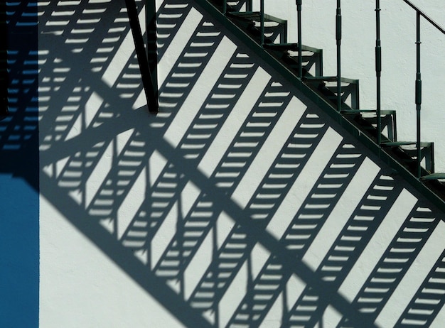 Foto escalera metálica con sombra en la pared