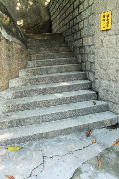 Escalera y pared de ladrillos de piedra gris con letrero amarillo en el Templo Ama de Macao China