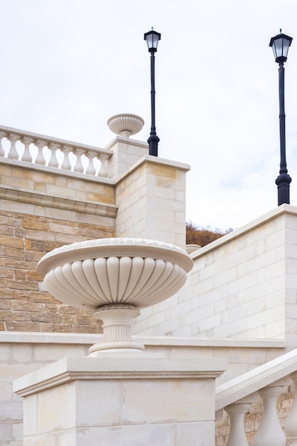 Escalera de piedra, decorada con columnas y macetas, farolas. Arquitectura y construcción.