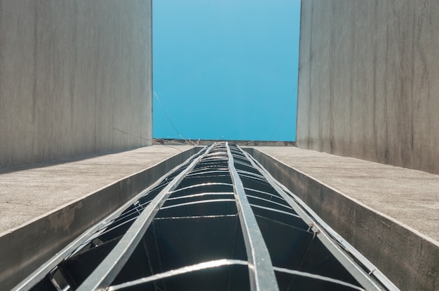 Escaleras de emergencia contra incendios en un edificio exterior con cielo azul arriba