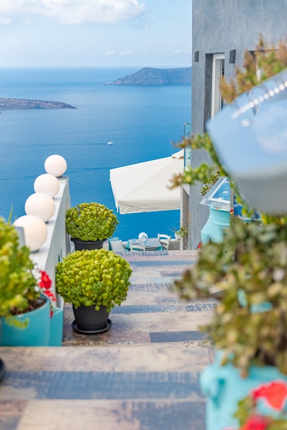 Escaleras idílicas con vistas a la calle con flores sobre vistas al mar Mediterráneo. Café, restaurante al aire libre