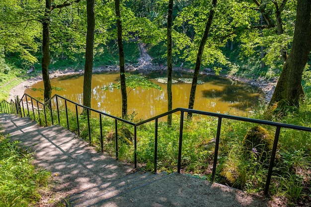 Escaleras que conducen al lago Lago redondo en el cráter del meteorito Kaali isla estonia de Saaremaa