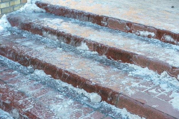 Los escalones cubiertos de hielo en las escaleras Mal tiempo en invierno La acera helada es peligrosa para caminar Riesgo de resbalón y caída