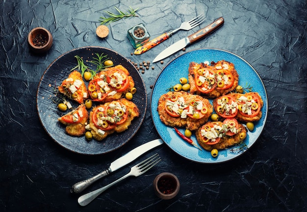 Escalope frito con aceitunas y tomate