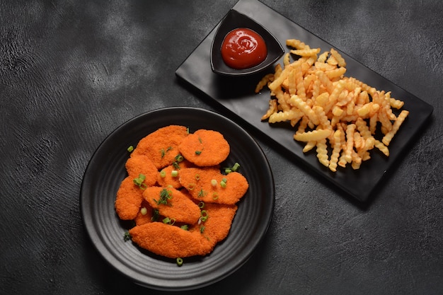 Escalope de pollo o nuggets con patatas fritas y salsa de tomate