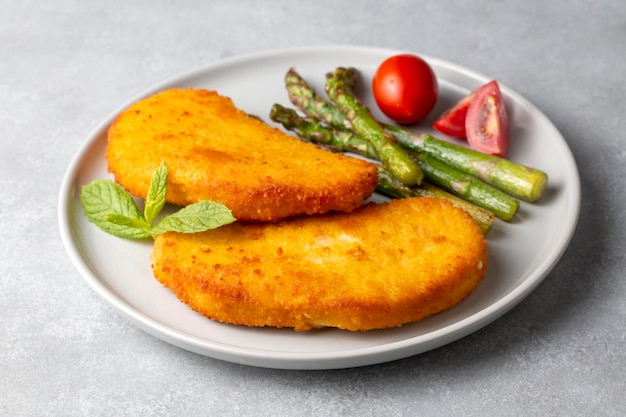 Escalope de pollo con salsa de patatas fritas y limón en un plato