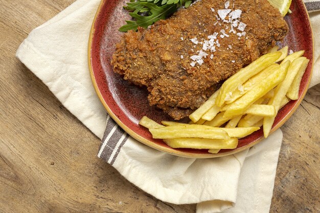 Escalope de ternera milanesa tradicional casero con patatas fritas, ensalada, salsa de mayonesa