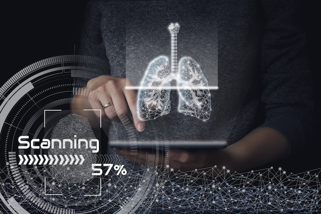 Escaneo de pulmones humanos en golograma de tableta. Fondo oscuro. El concepto de pulmones sanos.