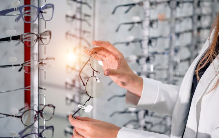 Escaparate con anteojos en tienda oftálmica moderna. Manos con gafas. De cerca.