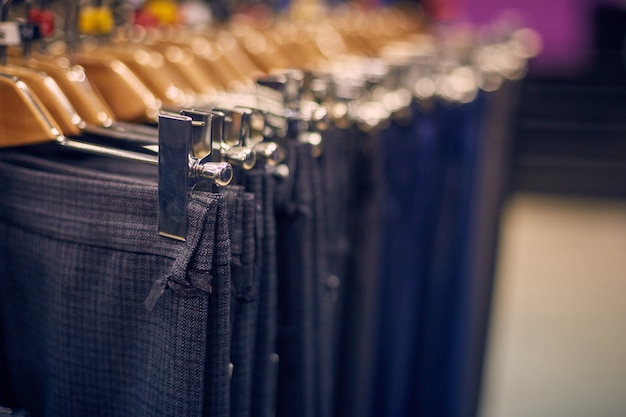 Escaparate con pantalones de hombre en perchas en una tienda de hombres