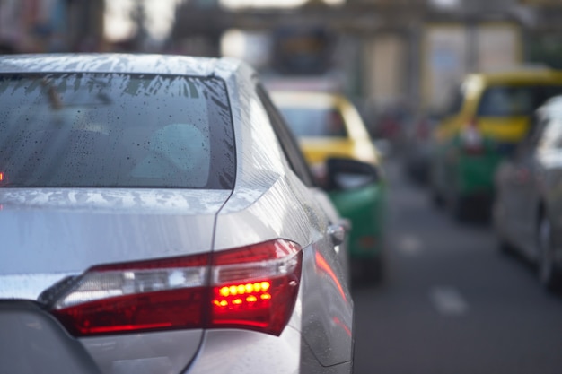 Escarcha de agua y gotas en el parabrisas trasero del automóvil sedán en la temporada de lluvias en el tráfico