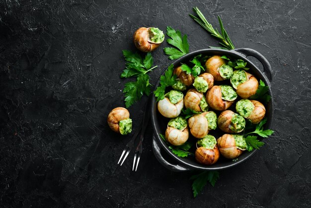 Escargots de Bourgogne caracoles horneados con mantequilla de ajo y albahaca Comida tradicional francesa Vista superior Espacio libre para su texto