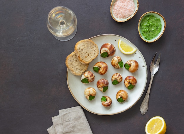 Escargots de Bourgogne. Caracoles con mantequilla de hierbas. Comer sano. Comida francés.