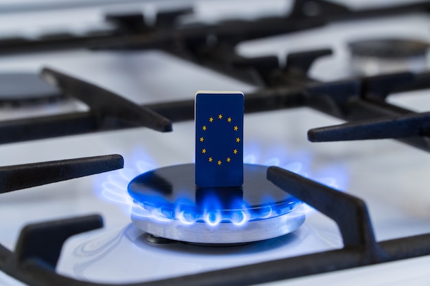 Escasez y crisis del gas. Bandera de la Unión Europea en una estufa de gas ardiente