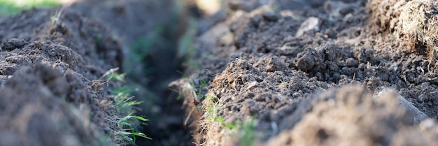 Escavação de terraplenagem de trincheiras e escavação de valas longa trincheira de terra é cavada para colocação de tubos ou fibras