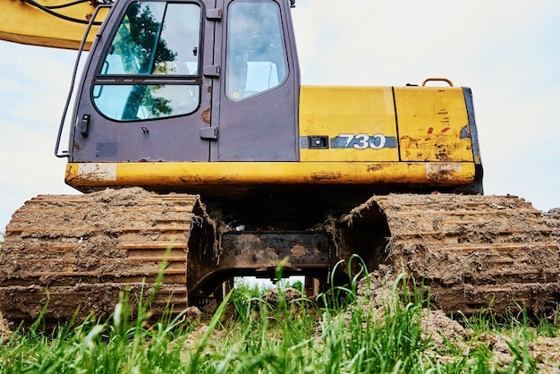 Escavadeira amarela na máquina de construção pesada do canteiro de obras escavando a retroescavadeira do solo