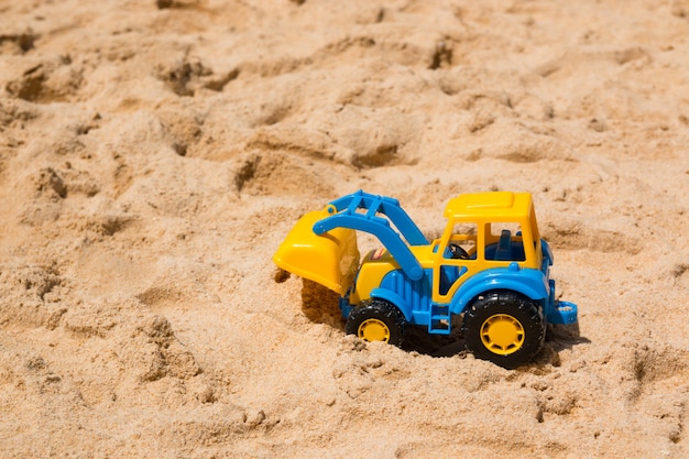 Foto escavadeira de brinquedo infantil na areia