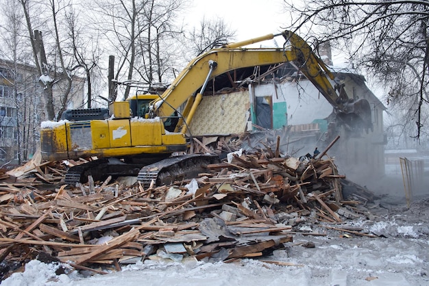 Escavadeira de demolição de construção quebra casa antiga Paisagem urbana industrial com processo de destruição