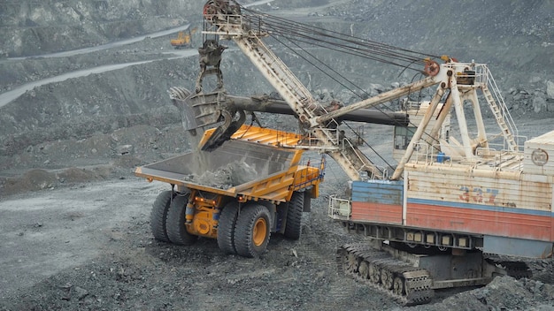 Foto escavadeira de mineração coletando minério em uma pedreira próxima à mineração de calcário