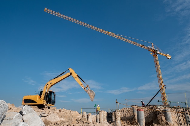 Escavadeira e guindaste de torre no canteiro de obras