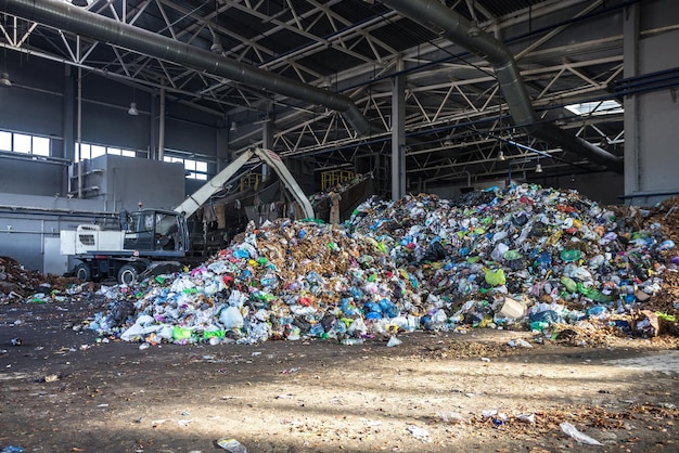 Escavadeira empilha lixo em grande pilha na classificação moderna usina de processamento de reciclagem de resíduos Separar e classificar a coleta de lixo Reciclagem e armazenamento de resíduos
