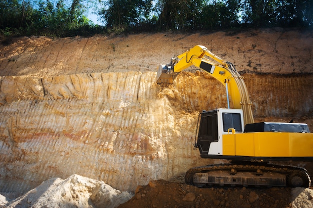 Escavadeira industrial trabalhando no canteiro de obras para limpar a terra de areia e solo