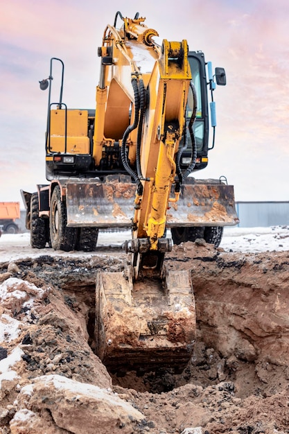 Escavadeira poderosa cava um poço de fundação para a construção de um edifício residencial. Carregando terra em um caminhão basculante. produção de construção. Escavação. Fechar-se.