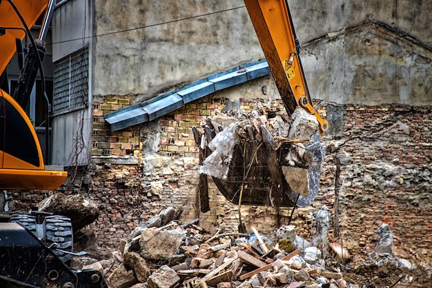 Escavadeira quebra casa velha Liberando espaço para a construção de um novo prédio