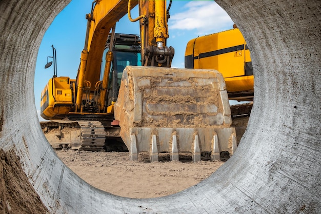 Escavadeiras poderosas em um canteiro de obras contra um céu azul nublado Equipamento de construção de terraplenagem Muitas escavadeiras